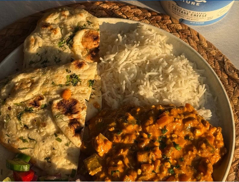 Plate of cottage cheese tikka masala served with fluffy basmati rice and garlic naan, made with Good Culture cottage cheese for a creamy, high-protein twist on a classic comfort dish.